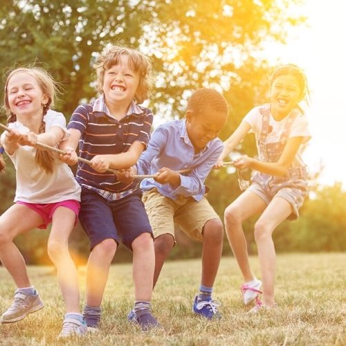kids smiling with white teeth laughing kids playing tug a war